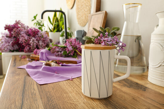 Cup With Small Twig Of Lilacs On Kitchen Counter