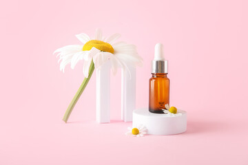 Composition with bottle of essential oil, plaster podiums and chamomile flowers on pink background