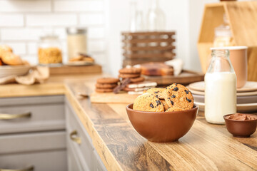 Bowl with cookies on wooden table in kitchen