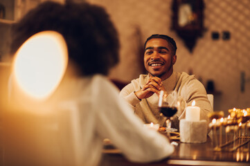 African american couple having romantic date and drinking wine at home