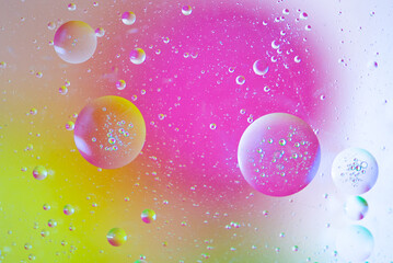 Close-up of oil bubbles and drops on colorful watery background