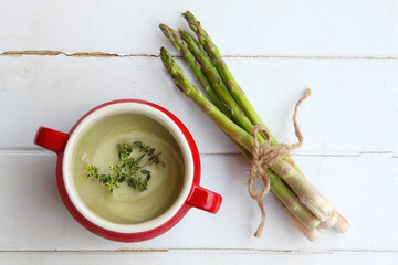 Asparagus soup in a red bowl - 608817736