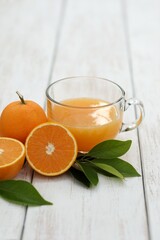 Fresh juice from oranges, in a transparent cup, cut in half, on a white table, vitamin drink, background image, background