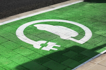 Special place for charging electric cars or vehicles. Green E- Car charging station sign in a...