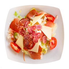 Catalan salad with sausage, cheese and vegetables served in a plate. Isolated over white background