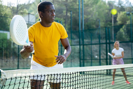 Portrait of an african american padel tennis player playing during a friendly doubles match on the outdoor court