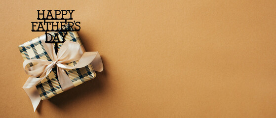 Vintage gift box with ribbon bow on brown background with copy space. Vintage style. Happy Fathers Day concept.