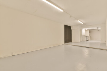 an empty room with white walls and light fixtures on the ceiling, there is a door that leads to...