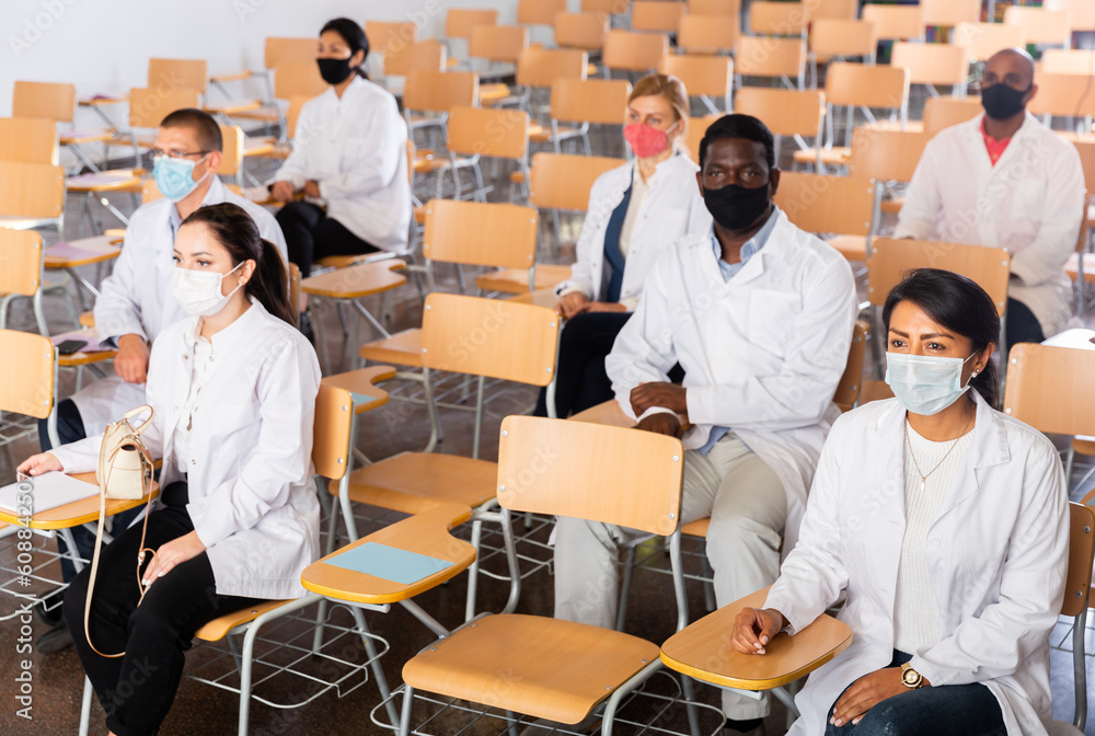 Canvas Prints multiethnic group of young adult medicals in protective face masks attentively listening to lecture 