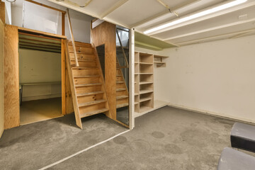 the inside of an unfinished room with stairs leading up to the second floor and storage space on the right side