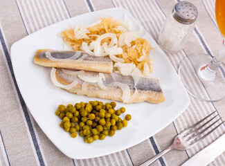 Service plate containing light salted herring with marinated cabbage and green peas