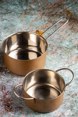 Set of cookware on the table. Metallic pans.