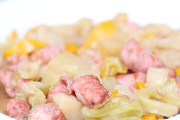 dish made of sausage, cabbage and vegetables. cabbage with sausage with selective focus. meal texture.