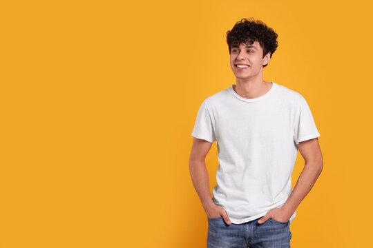 Portrait of handsome young man on orange background. Space for text