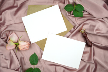 Double sided two landcape 5x7 invitation cards wedding program stationery suite card mock-up styled with vintage wax seal, and pink rose, on a crushed dusty rose satin background.