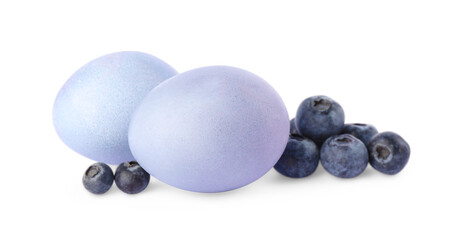 Colorful Easter eggs painted with natural dye and fresh blueberries on white background