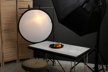 Fototapeta na wymiar Composition with baked chicken, parsnip and strawberries on grey table in professional photo studio. Food photography