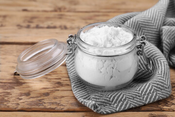 Glass jar of natural starch on wooden table, closeup