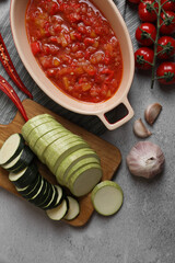 Dressing for ratatouille and different fresh vegetables on light grey table, flat lay