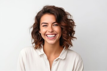 Portrait of a beautiful young woman with long curly hair smiling on a white background