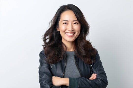Portrait of happy young asian woman in leather jacket on white background