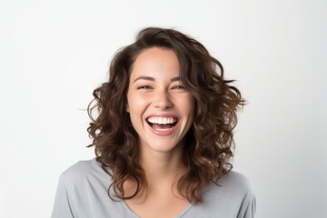 Closeup portrait of a happy young woman laughing isolated on a white background