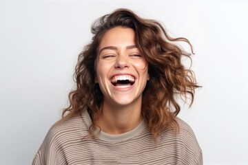 Portrait of a happy young woman laughing and looking at camera isolated over white background