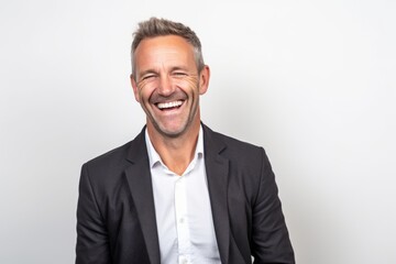 Portrait of happy mature businessman laughing and looking at camera on white background