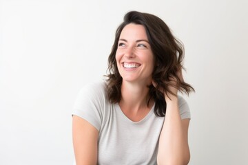 Portrait of a beautiful young woman with long wavy hair smiling on white background