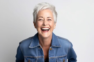 Portrait of a happy senior woman laughing on a white background.
