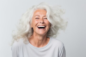 Portrait of a happy senior woman laughing at camera isolated on a white background