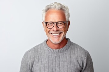 Portrait of smiling senior man in eyeglasses against white background