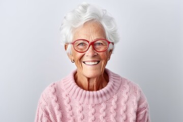 Portrait of a happy senior woman wearing eyeglasses against grey background