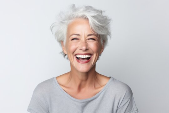 Portrait Of Happy Senior Woman With White Hair Laughing Over White Background