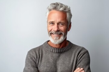 Obraz premium Portrait of a senior man with grey hair and beard on grey background