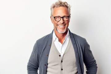 Portrait of a handsome mature man in eyeglasses looking at camera and smiling while standing against white background