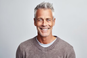 Portrait of a happy mature man looking at camera over gray background