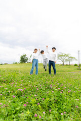 若い日本人家族のポートレート、新緑の季節の公園で撮影