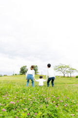 若い日本人ファミリーの後姿　新緑の公園で撮影