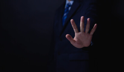 male hand showing stop gesture Concept of stop violence. Warning, prohibition, denial. On dark...