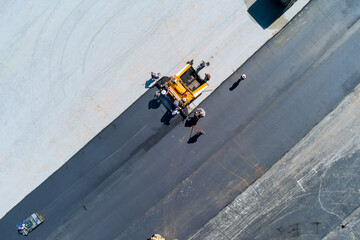 Roadwork team is ensuring that parking lot is properly prepared before applying asphalt layer near...