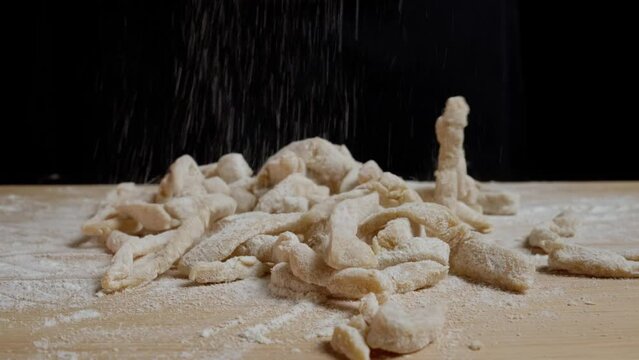 dropping pasta line with flour on a wooden board - macro shot zoming out while rotating