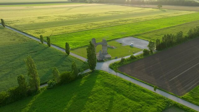Heidentor Ruins On Scenic Field In Carnuntum, Austria - aerial drone shot 