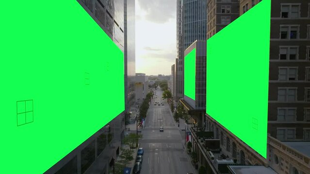 Aerial view over city streets with green screen billboard walls - 3D animation