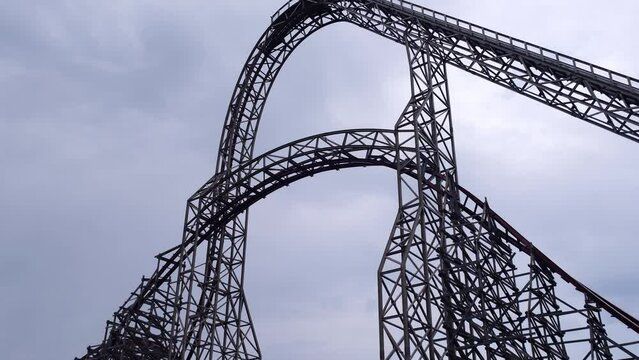 Riding the roller coaster at Energylandia Zator Poland amusement park. Solar powered roller coaster. Rollercoaster against blue sky sunset Wooden outdoor leisure family time 