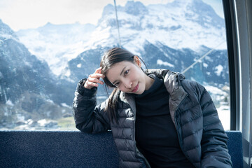 Woman tourist sitting in cable car enjoying view. Grindelwald first, Switzerland.