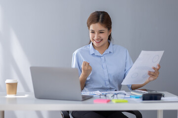 Excited asian woman sit at desk feel euphoric win online lottery, happy asian woman overjoyed get...