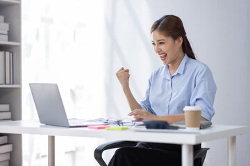 Excited asian woman sit at desk feel euphoric win online lottery, happy asian woman overjoyed get...