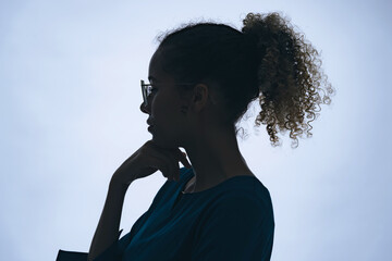 Profile silhouette of thinking black woman in studio shot.
