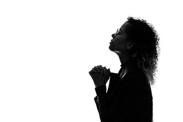 Profile silhouette of praying black woman in studio shot.